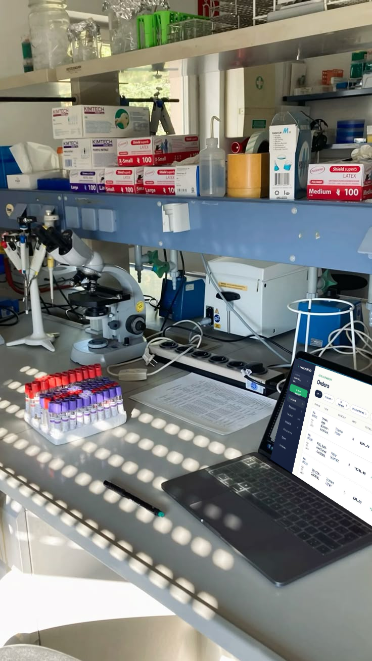 A client lab bench with the ProcureWide portal open on a laptop